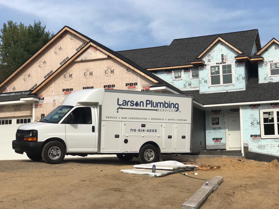 Larson Plumbing Services van at a new construction job site in the Chippewa Valley
